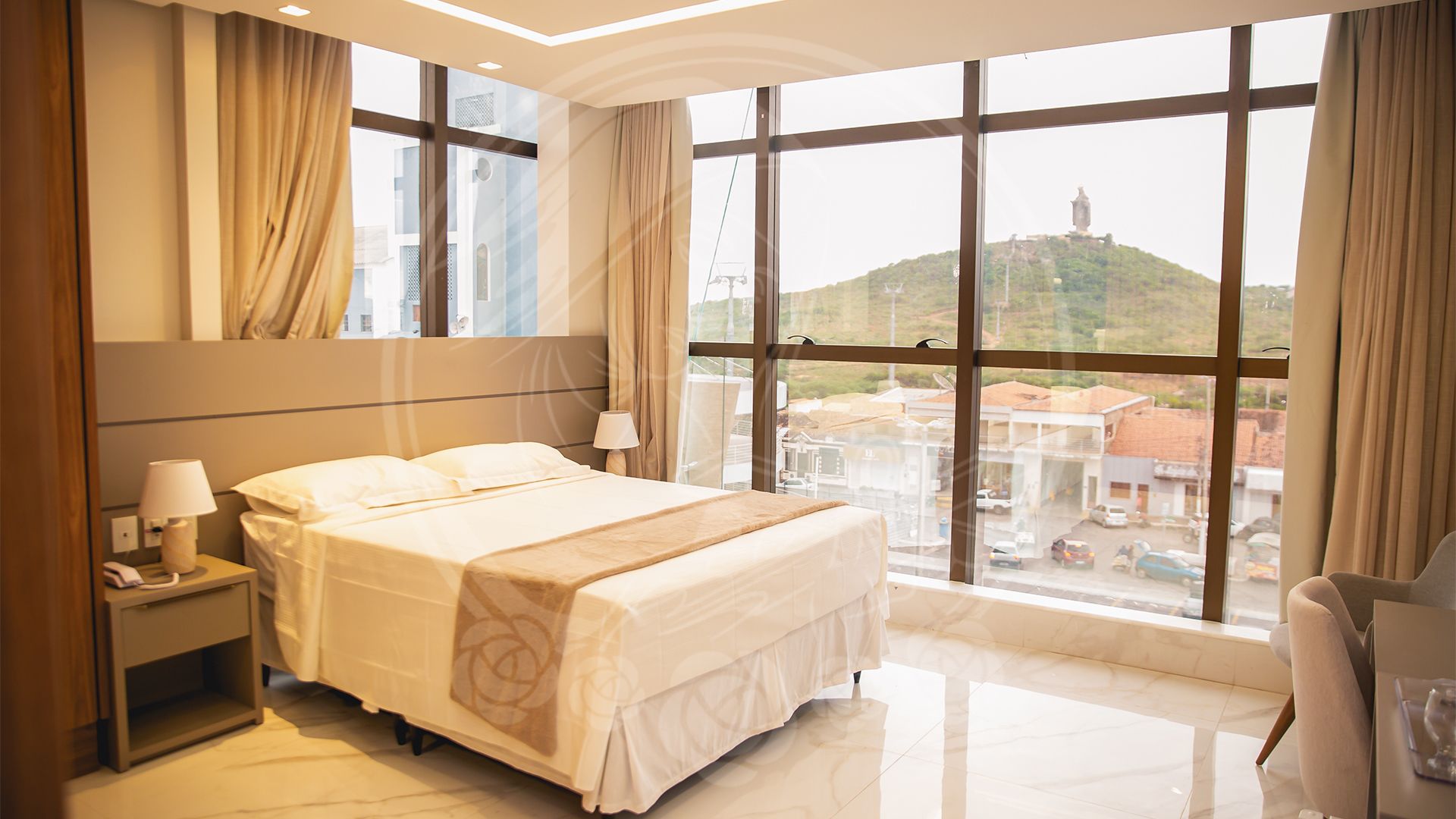 Quarto do Hotel Santa Rita com janelas amplas e vista para o morro da Santa Rita