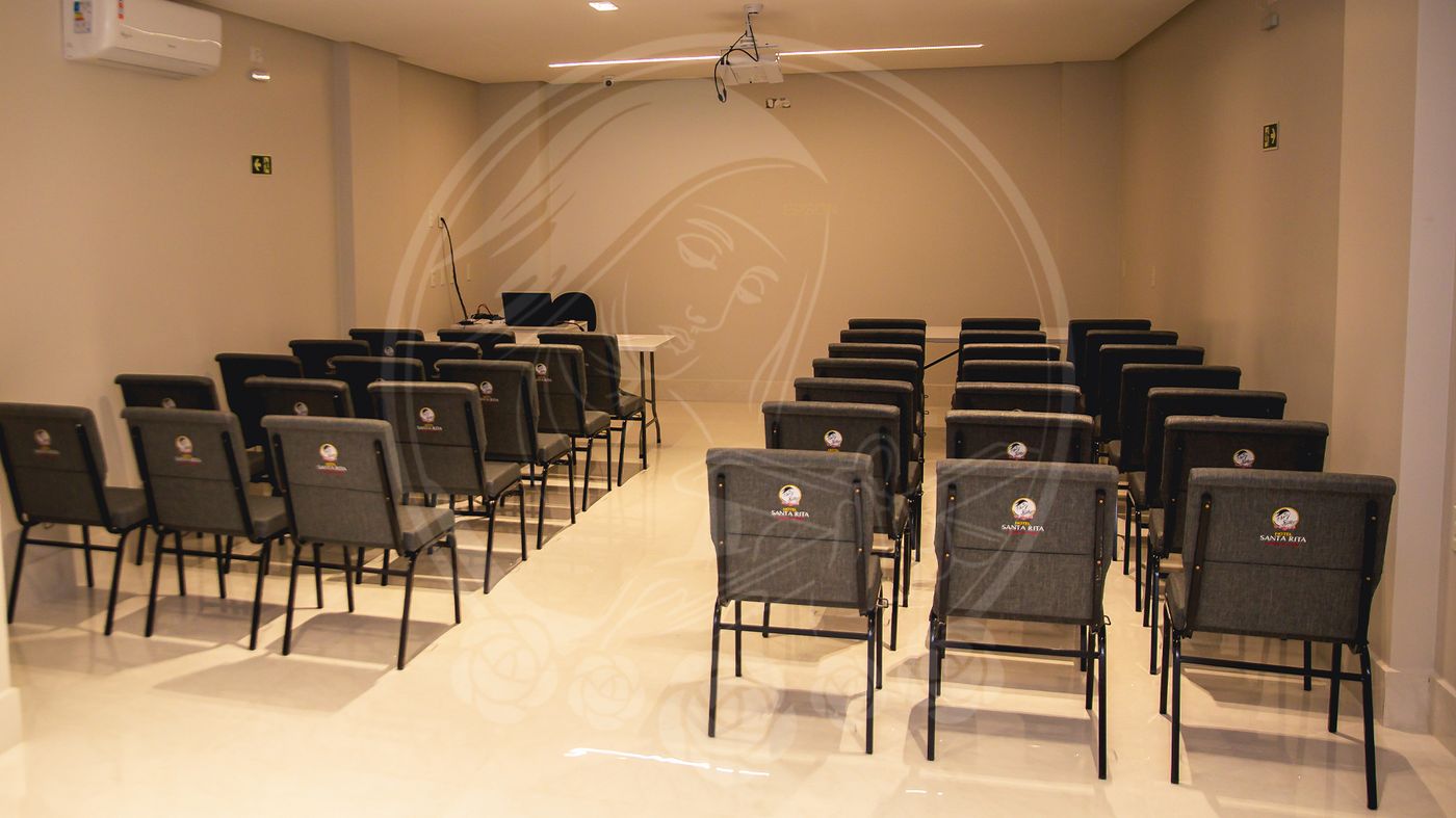 Sala de eventos com cadeiras estofadas e projetor